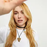 Collar largo con hilo de seda negro y dije de alas de ángel en aleación de metales bañada en oro de 18k.