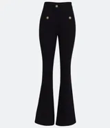 Pantalón flare negro de punto roma, con cintura alta, bolsillos delanteros con botones metálicos estilo escudo y cierre por cremallera y botón.