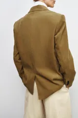 Blazer oversize de pana con cuello solapa y manga larga. Presenta cierre frontal cruzado con botones, bolsillos delanteros y forro interior a tono.