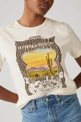 Remera de manga corta color crema con estampa frontal de Levi's con un paisaje desértico y la leyenda "Authentic Levi Strauss & Co. Established in 1873. More than a well worn legend".