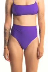Bombacha de bikini tiro alto color violeta, de corte colaless. Confeccionada en lycra doble con faja en la cintura para un ajuste cómodo y seguro.