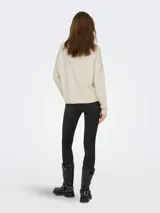 Sweater de punto color beige con cuello redondo, mangas largas y detalle de trenzado vertical en el frente. Presenta puños y ruedo acanalados.
