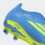 Championes de fútbol Adidas F50 Club, diseñados para terreno firme y multiterreno. Presentan un exterior sintético texturizado en color azul con detalles en amarillo neón, incluyendo las icónicas tres tiras de la marca. Cuentan con suela FXG para tracción óptima en pasto natural y sintético, y lengüeta sintética liviana.