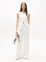 Pantalón de vestir Tommy Hilfiger de corte amplio y pierna recta, confeccionado en mezcla de lino elástico. Presenta diseño plisado en la parte delantera y trasera, bolsillos laterales abiertos y bolsillos traseros con solapa.