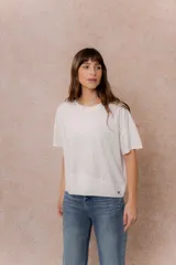 Remera negra de corte oversize con cuello redondo, mangas cortas amplias, hombros caídos y recortes delanteros.