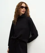 Buzo de corte regular confeccionado en mezcla de poliéster, viscosa y elastano. Presenta cuello alto estructurado, mangas largas con corte raglán y puños ajustados.