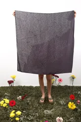 Pañuelo cuadrado de poliéster y elastano, color negro con estampado de la palabra "CAPER" repetida en blanco. Mide 1 metro x 1 metro.