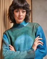 Vestido celeste con teñido artesanal tie dye en forma de luna, cuello alto cruzado y aberturas laterales.