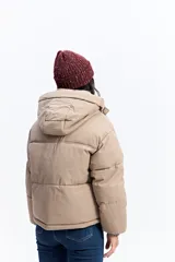 Campera puffer color crema con capucha, cuello alto, cierre frontal y puños elásticos.