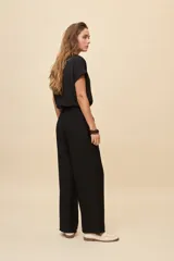 Pantalón gris de corte amplio y silueta fluida, con cintura elástica y cordón ajustable.