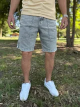 Bermuda de jean gris claro con efecto acid wash, bolsillos delanteros aplicados y costuras destacadas.