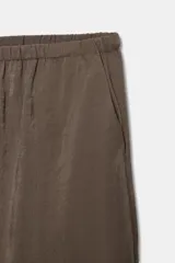 Pantalón negro de tiro medio, con cintura elástica y cordón ajustable. Tiene bolsillos delanteros y bajo ajustable con cordones del mismo tejido.