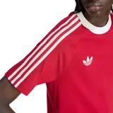 Remera de fútbol Adidas Originals del Manchester United, color rojo con cuello redondo y detalles en blanco, incluyendo las clásicas tres tiras en las mangas, el logo del trébol y el escudo del club en el pecho.