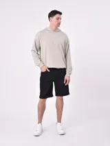 Bermuda de denim color negro, corte recto con dobladillo en el borde inferior y bolsillos clásicos.
