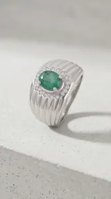 Anillo de plata 925 con diseño robusto, presenta una piedra central ovalada de esmeralda rodeada por un halo de circonias brillantes.