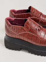 Mocasines con plataforma de goma negra, confeccionados en lona con estampa a cuadros en tonos violeta, amarillo y beige, y detalle de elásticos laterales ocultos.
