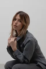 Chaqueta de denim de algodón con corte entallado en la cintura, cuello clásico, cierre frontal con botones metálicos y dos bolsillos con solapa en el pecho.