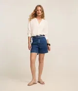 Short de jean tiro alto con trabillas y bolsillos, confeccionado en algodón denim azul con pespuntes contrastantes.