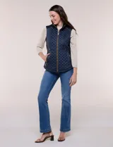 Chaleco acolchado de diseño entallado color beige, con matelaseado en patrón de rombos en frente y espalda, cuello alto estructurado y cierre frontal completo con cremallera metálica y ribete a contraste.