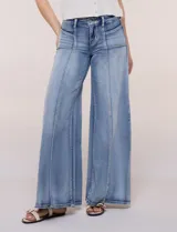Jean wide leg de tiro alto en denim azul claro, con calce ajustado en la cadera, costuras verticales frontales y bolsillos estilo carpintero.