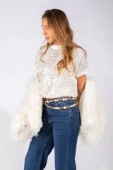 Remera blanca de manga corta con diseño de lentejuelas plateadas en toda la parte frontal, cuello redondo y ajuste al cuerpo.