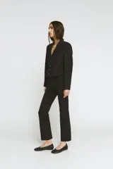 Blazer corta negra de la colección Zara Woman, con cuello solapa de muescas y manga larga. Presenta detalles de pespuntes marcados y forro interior a tono. Cierre frontal con botones.
