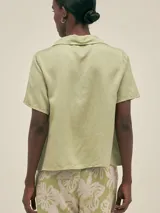 Camisa verde claro de manga corta con cuello camisero y botones.