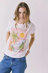 Remera blanca de manga corta y cuello redondo, con estampa frontal de paisaje costero mediterráneo con palmeras y sol, y la inscripción 'Costa del Sol'.
