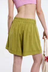 Short negro de algodón con pinzas, tiro alto, pretina con botón frontal y bolsillos laterales.