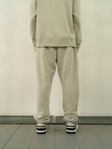 Pantalón de jogging estilo relaxed fit, confeccionado en felpa color beige, con cintura elástica, puños en los tobillos y logo de la marca sutilmente estampado en la pierna.