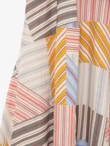 Vestido largo de viscosa con diseño asimétrico, tirantes finos, escote en V y estampado de líneas diagonales amarillas sobre fondo rosado.