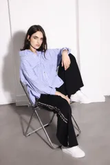 Camisa celeste con rayas verticales blancas, de corte holgado y mangas largas.