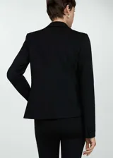 Blazer negro de corte recto y estilo sastre, con cuello de solapa con muesca, cierre frontal de un botón, mangas largas con puños abotonados y dos bolsillos delanteros con solapa.