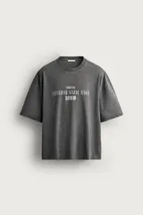 Remera de corte relaxed fit con efecto lavado, cuello redondo y manga corta, con estampado frontal contrastante.