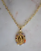 Cadena dorada con dije ovalado de la Virgen María en baño de oro, rodeado de pequeños cristales de colores variados.