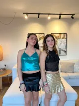 Top halter negro con lentejuelas plateadas y blancas, breteles finos que se atan al cuello y espalda descubierta.