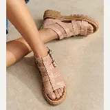 Sandalias de cuero vacuno color nude con textura símil reptil, diseño de tiras cruzadas tipo gladiadora, doble hebilla metálica de ajuste lateral y suela flatform de goma con plataforma track.