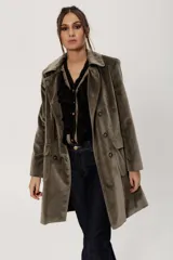 Chaqueta de terciopelo color verde oliva, con cuello solapa, doble botonadura y corte holgado.