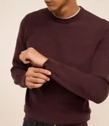 Suéter marrón de punto con textura en zigzag, cuello redondo y manga larga.