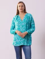 Blusa de gasa estampada con flores, marca Grand & Greene. Tiene cuello a la base, escote en V y abertura con botones.