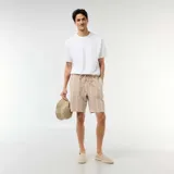 Bermuda beige a rayas blancas, de corte recto, con cintura elástica y cordón ajustable.