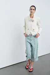 Jeans capri de tiro medio con cintura con trabillas y cinco bolsillos. Presenta pespuntes marcados a contraste y bajo acabado en vuelta.