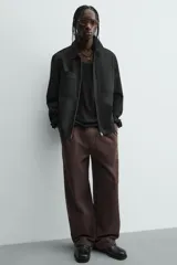 Pantalón jogger de algodón color marrón oscuro, de corte relajado y pierna ancha. Presenta cintura elástica con cordón ajustable y bolsillos laterales y uno trasero de plastrón.