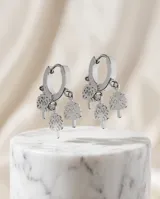 Aros tipo argolla pequeña de acero con tres dijes colgantes en forma de árbol de la vida.