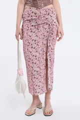 Pollera midi de viscosa con estampado floreado en tonos rosados, detalle de frunce regulable y tajo frontal. Cuenta con cintura elastizada.