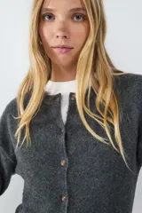 Cardigan de punto gris oscuro, de corte clásico y calce ajustado, con cuello redondo y cierre frontal de botones.