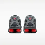 Championes Nike Shox Ride 2 en color gris humo, con tecnología de amortiguación Shox en el talón en color rojo vibrante. Presenta una parte superior de malla transpirable con superposiciones sintéticas y el logo Swoosh en el lateral.