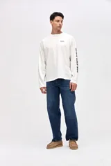 Remera manga larga de algodón lavado con textura suave, color gris oscuro, con estampado pequeño en el pecho y estampado en la manga.