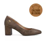 Zapato de tacón alto Usaflex, color negro con textura grabada, punta redondeada y detalle de logo metálico dorado en el lateral.