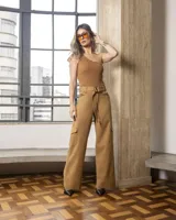 Pantalón color caqui, de corte ancho, con bolsillos laterales tipo cargo, cinturón con hebilla forrada y lazo.